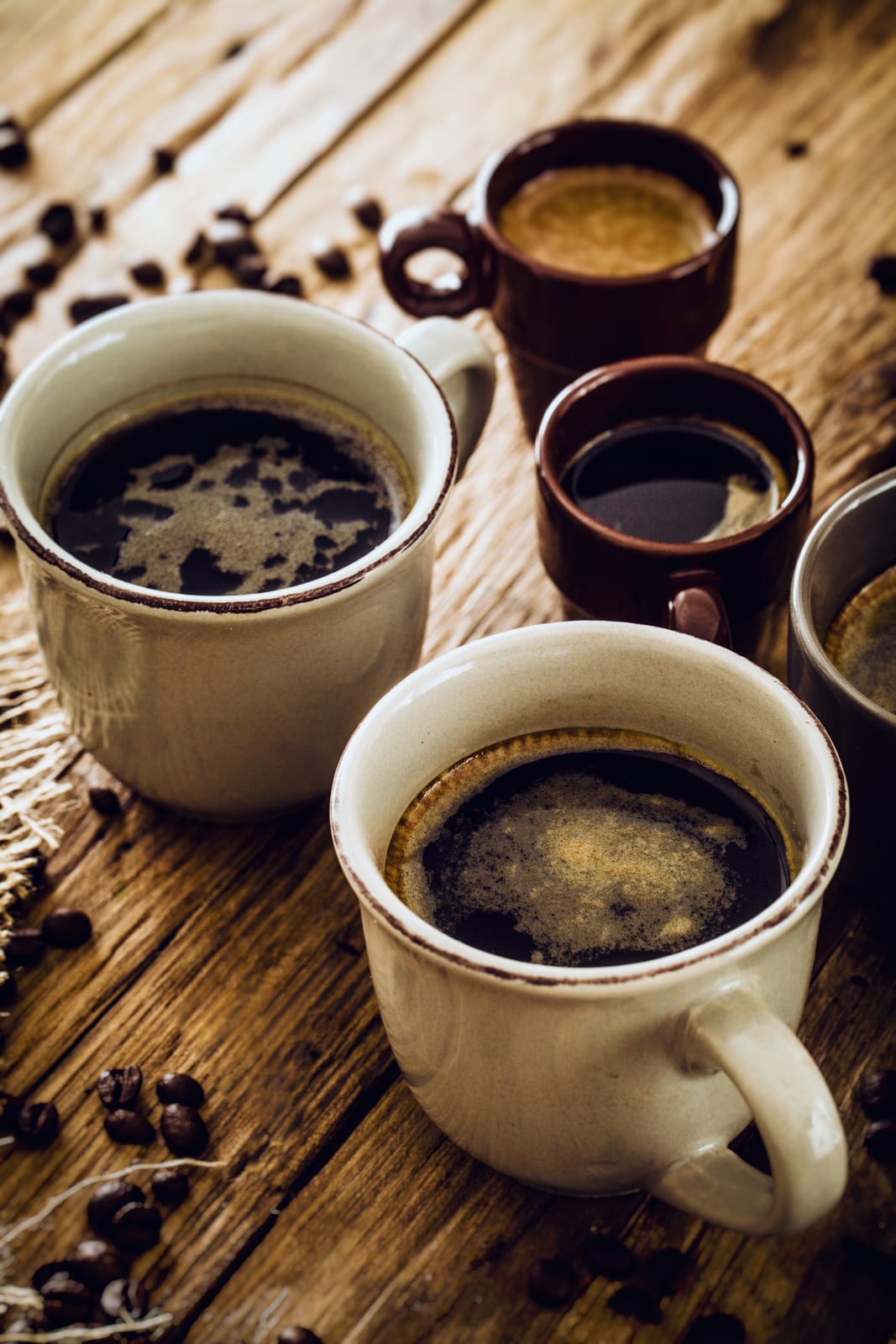 Three mugs of black coffee in different colours and sizes