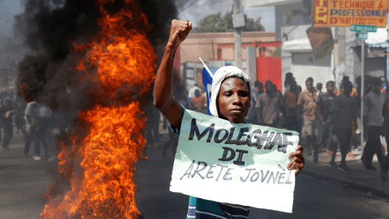A demonstrator gestures near a barricade during a protest against Haiti's President Jovenel Moise, in Port-au-Prince, Haiti, on February 14, 2021