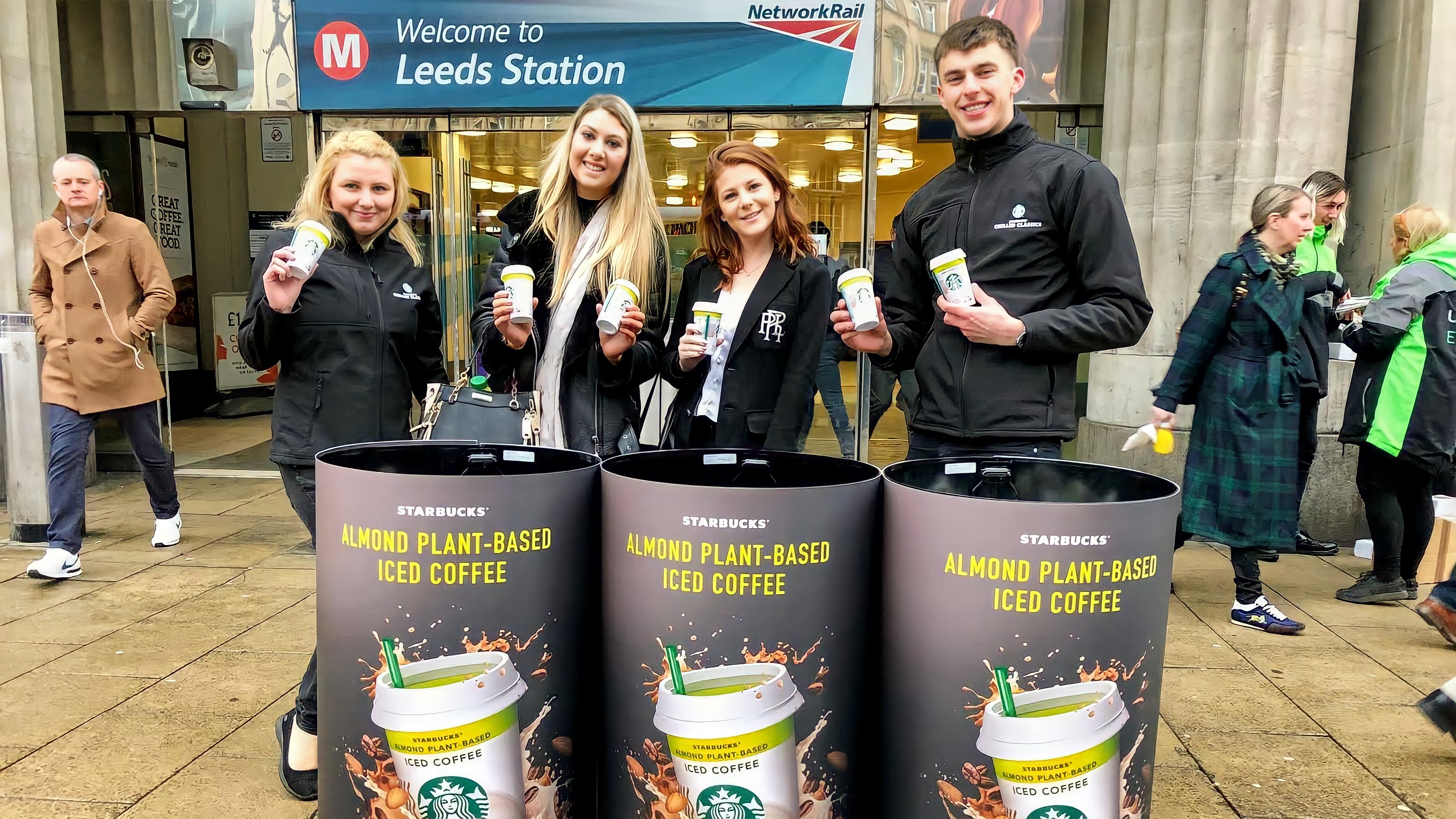 Executional team handing samples to commuters on a station concourse