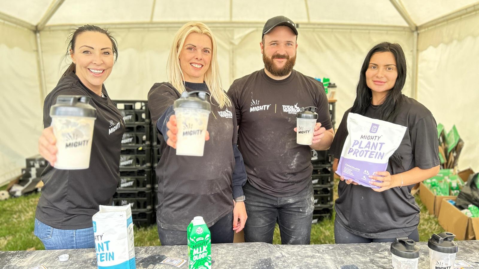 Executional staff serving Mighty plant protein shakes from a marquee at a show