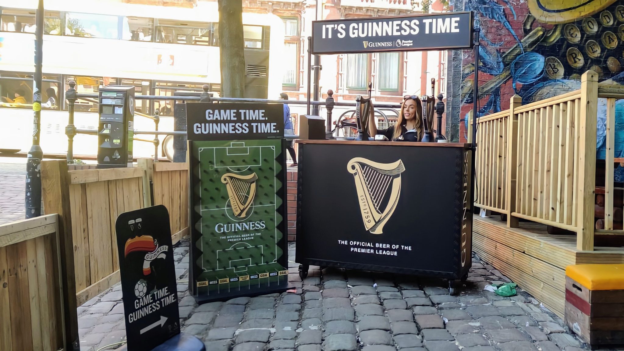 Black and gold branded bar with a harp logo at an outdoor venue