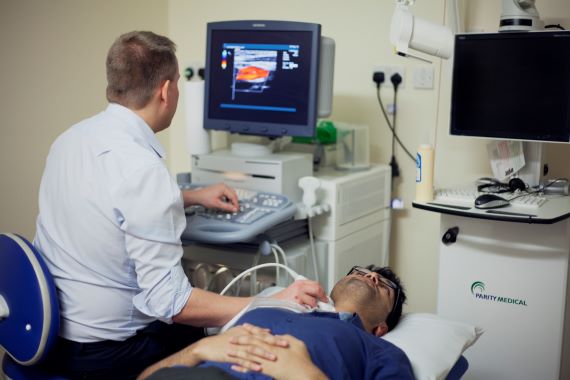 Doctor examining a patient's arteries with an ultrasound for a stroke screening