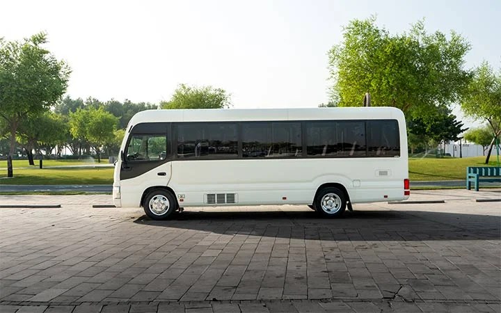Side view of Coaster bus with driver and fuel in Doha Qatar
