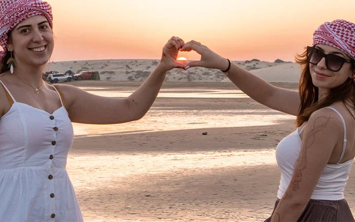 Tourists enjoying sunset views during Qatar desert safari excursion