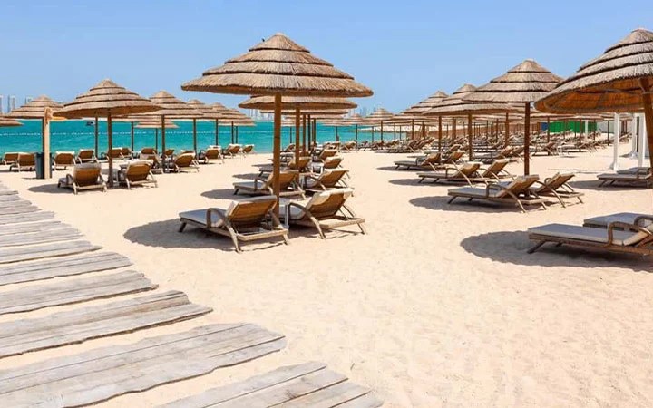 Umbrellas and loungers on golden sand in Doha