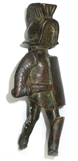 Bronze-colored figurine in detailed armor, shown in three-quarter profile. The face is completely smooth and has no features. 