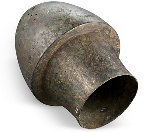 A hollow, bullet shaped vessel in a silvery brown color, lying diagonally on its side. 