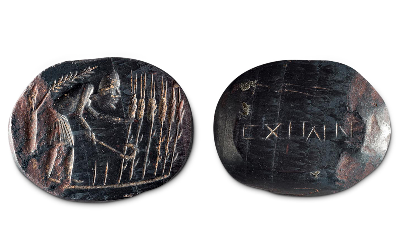 The front and back of an oblong, horizontally oriented stone of a blackish-blue hue. On the left, a frontal view shows a carved male figure cutting grain; on the right, a reverse view shows a carved line of text, possibly Roman numerals.