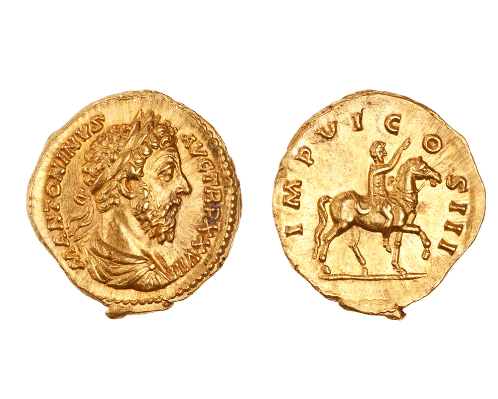 The front and back of a gold coin with images in relief. On the left, the coin shows a bearded man with a laurel wreath; on the right, the coin shows a rider on horseback with a textual border.