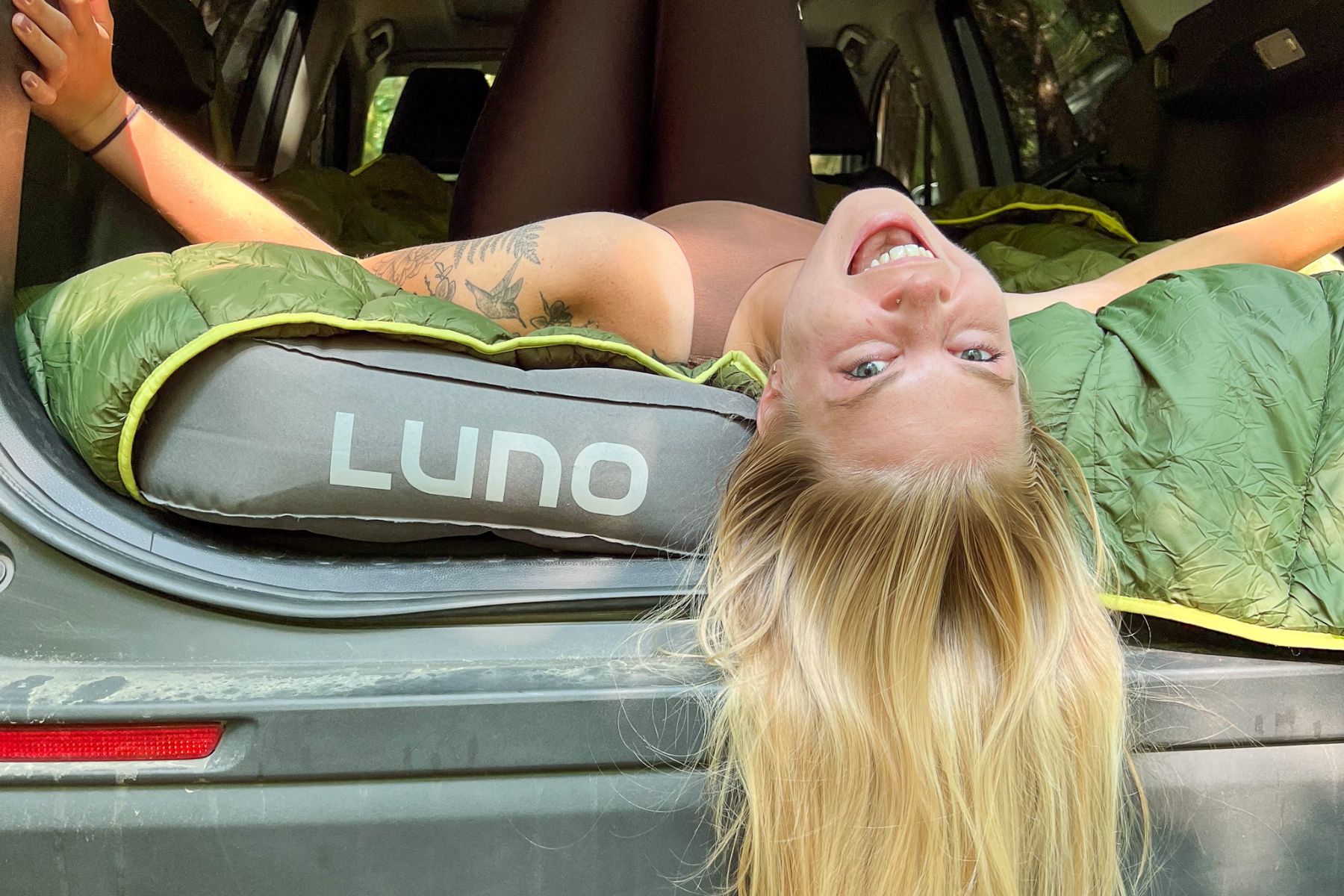 Woman laying in her car for car camping