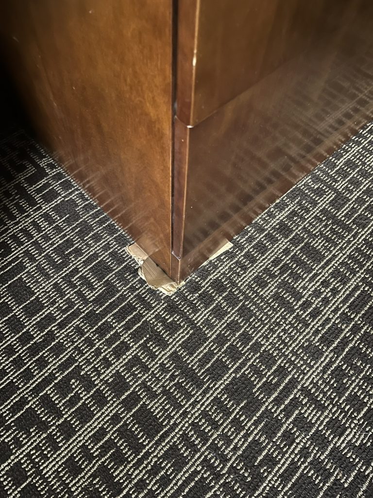 Cardboard under dresser corner
