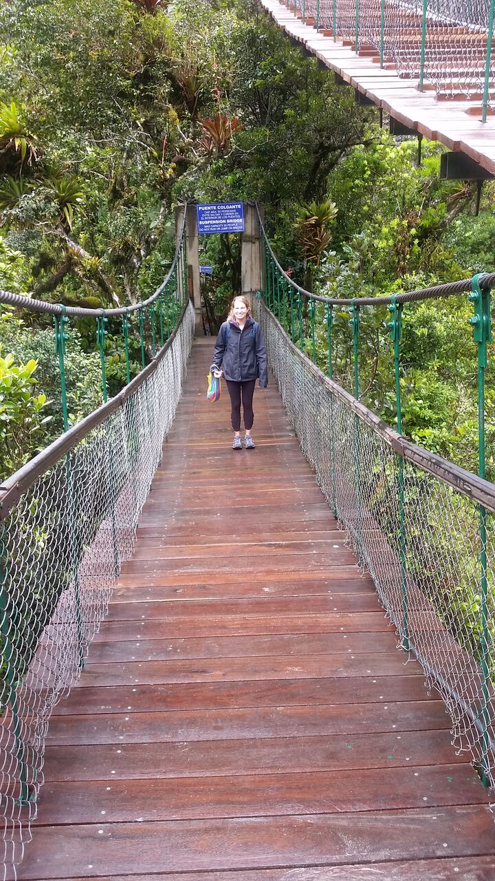 Girl on wooden bridge at Pailon del Diablo waterfall.