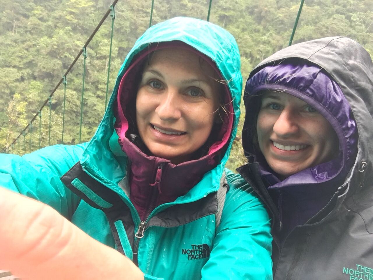 Girl on wooden bridge at Pailon del Diablo waterfall.