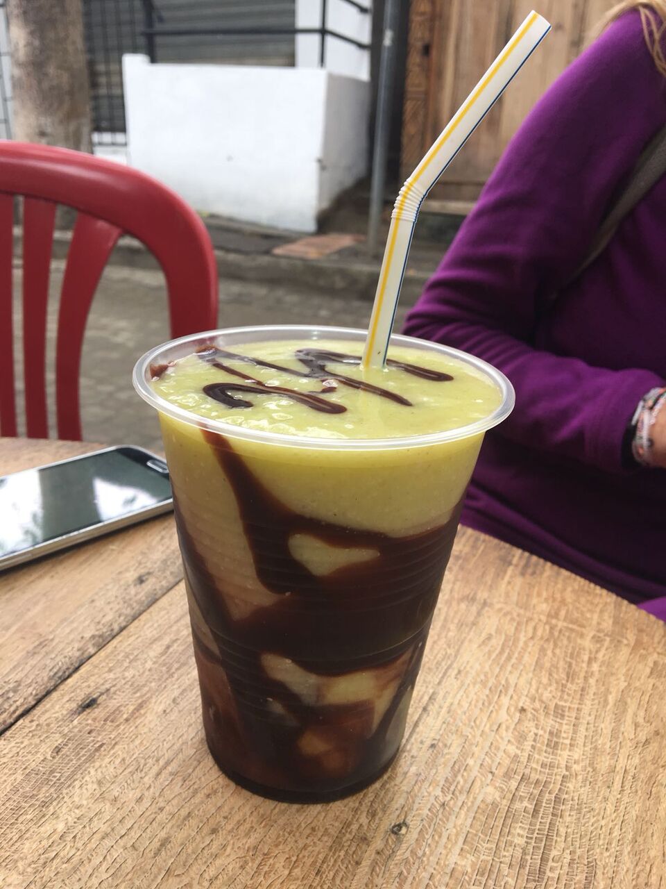 Green and brown swirled smoothie with straw.