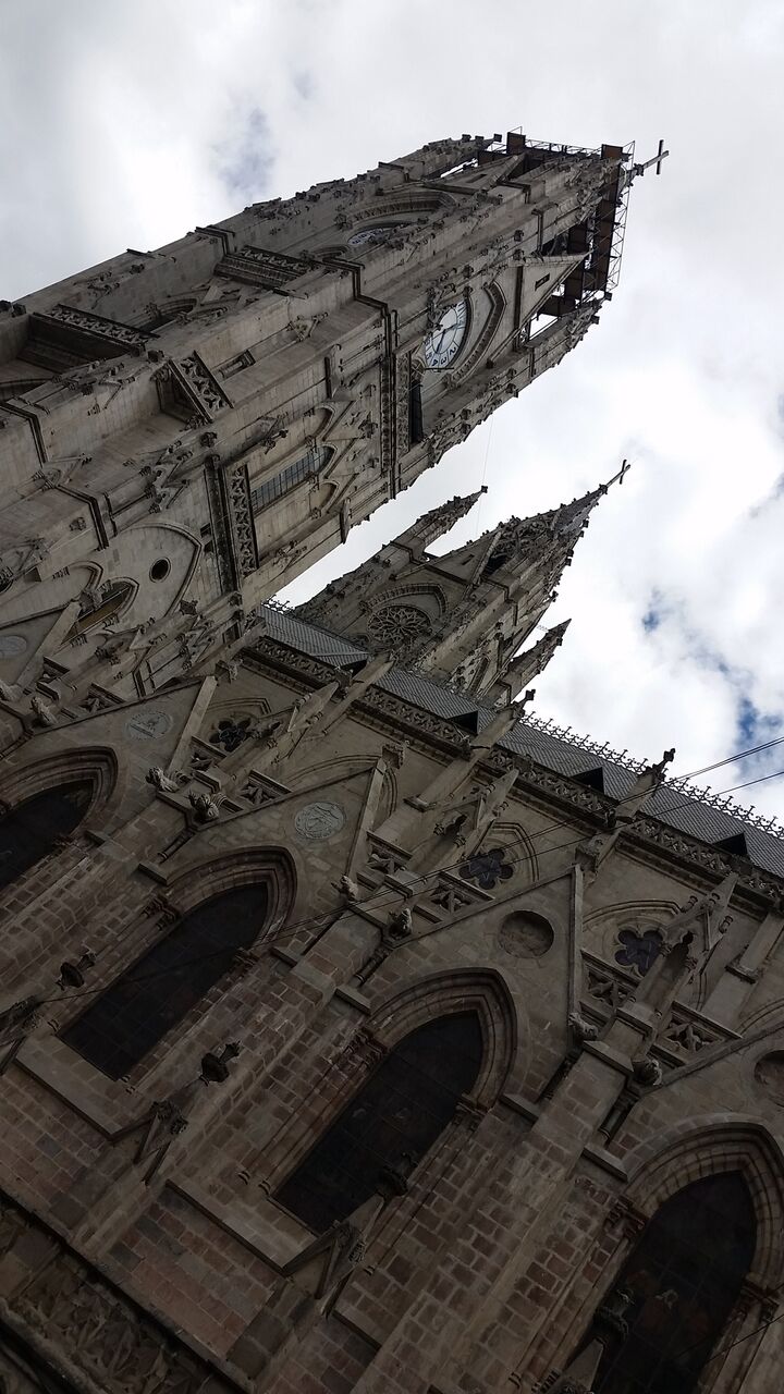 View of a massive church with animal gargoyles looking up from below.