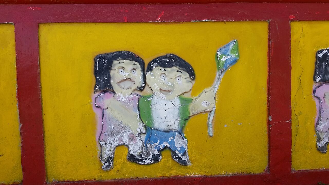 Girl and boy holding kite on a zocalo in Guataupe.