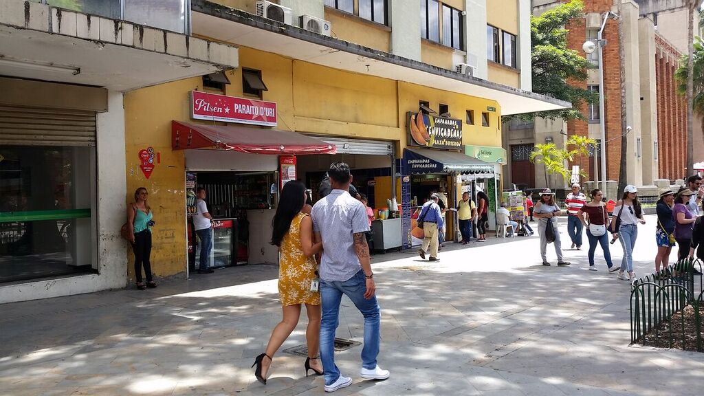 People walking down busy road in Medellin