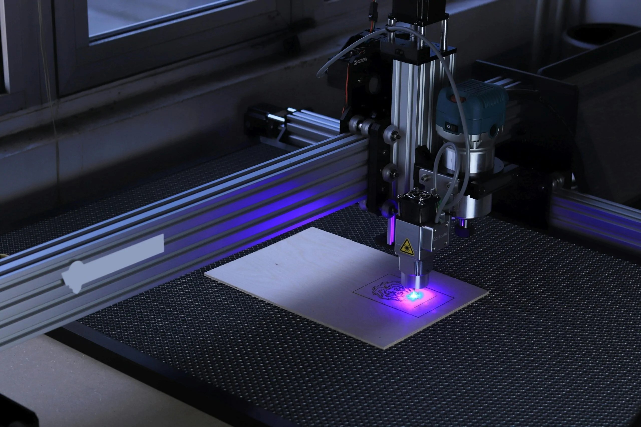 Close-up of a fiber laser cutting head and nozzle in operation on sheet metal