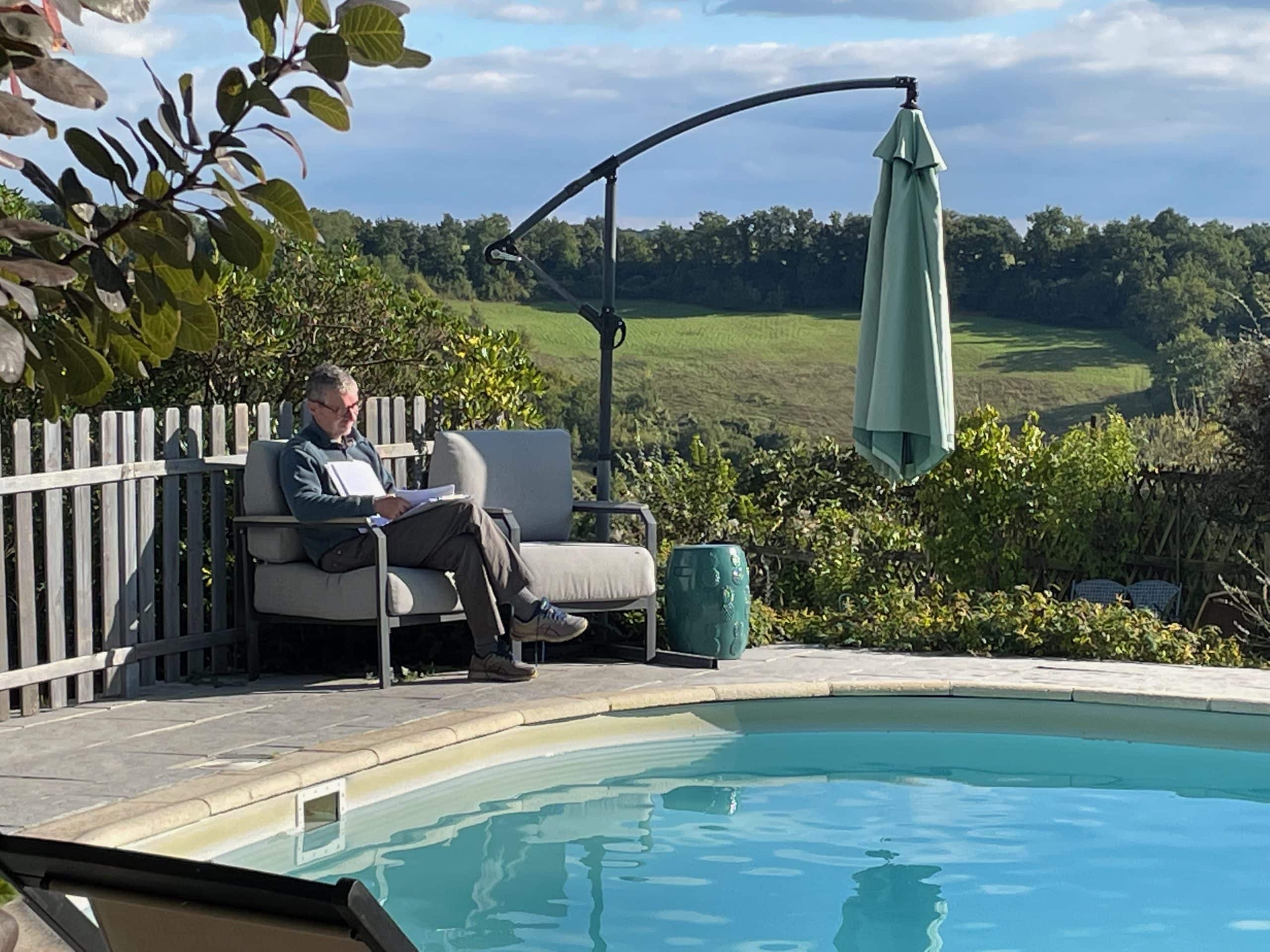un homme réfléchit au bord de la piscine de la Bergerie étoilée