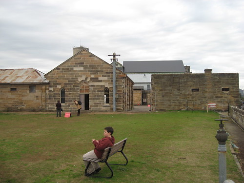 Tom having a rest with the Mess Hall and Barracks behind