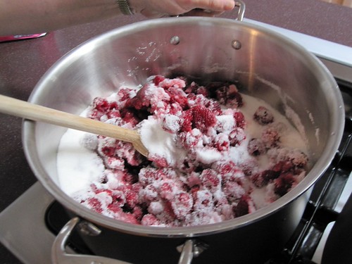 Mixing sugar and raspberries