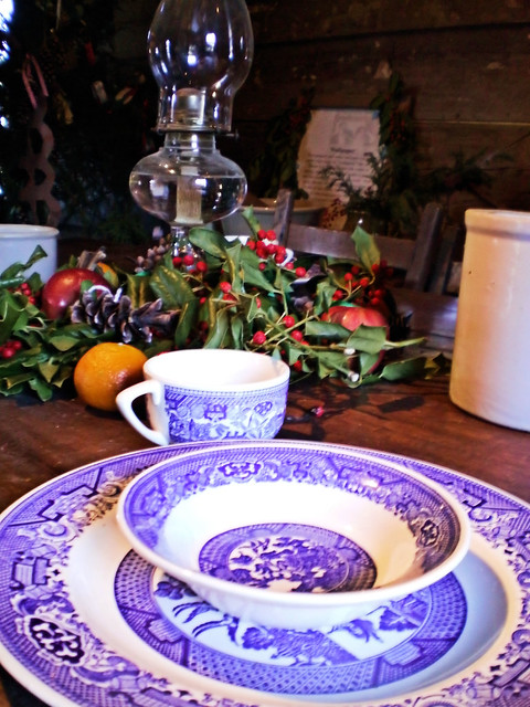 blue and white china place setting on table decorated for Christmas
