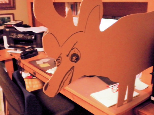 back side of a cardboard deer shaped target with funny angry face drawn on it