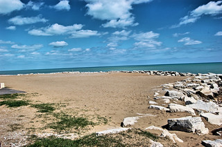 beach with blue sky, sand and rocks