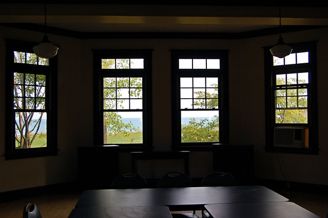 view of Lake Michigan's blue water across a green lawn through large bay window