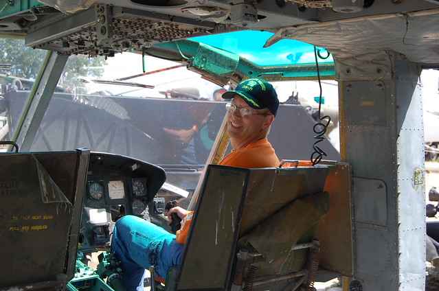 Mike wearing his cover from his time on the USS Theodore Roosevelt  and his UT Orange shirt (required for the fall Saturdays) sits in a helicopter seat