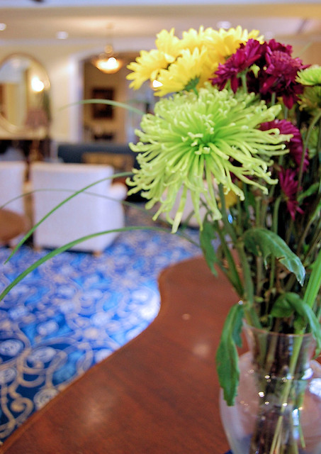 flower arrangement in foreground and blue lobby in background