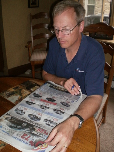 Mike looking through car ads in the paper