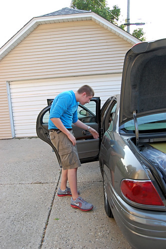 he looks over what he's packed in the back seat. 