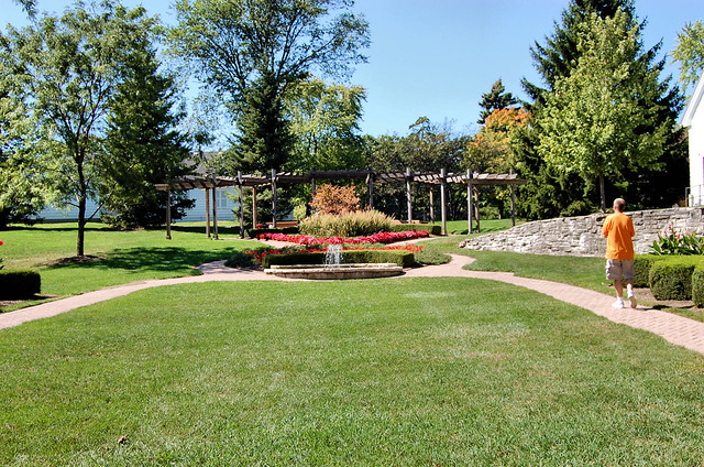 flower gardens around a small fountain leading up to a pavilion 