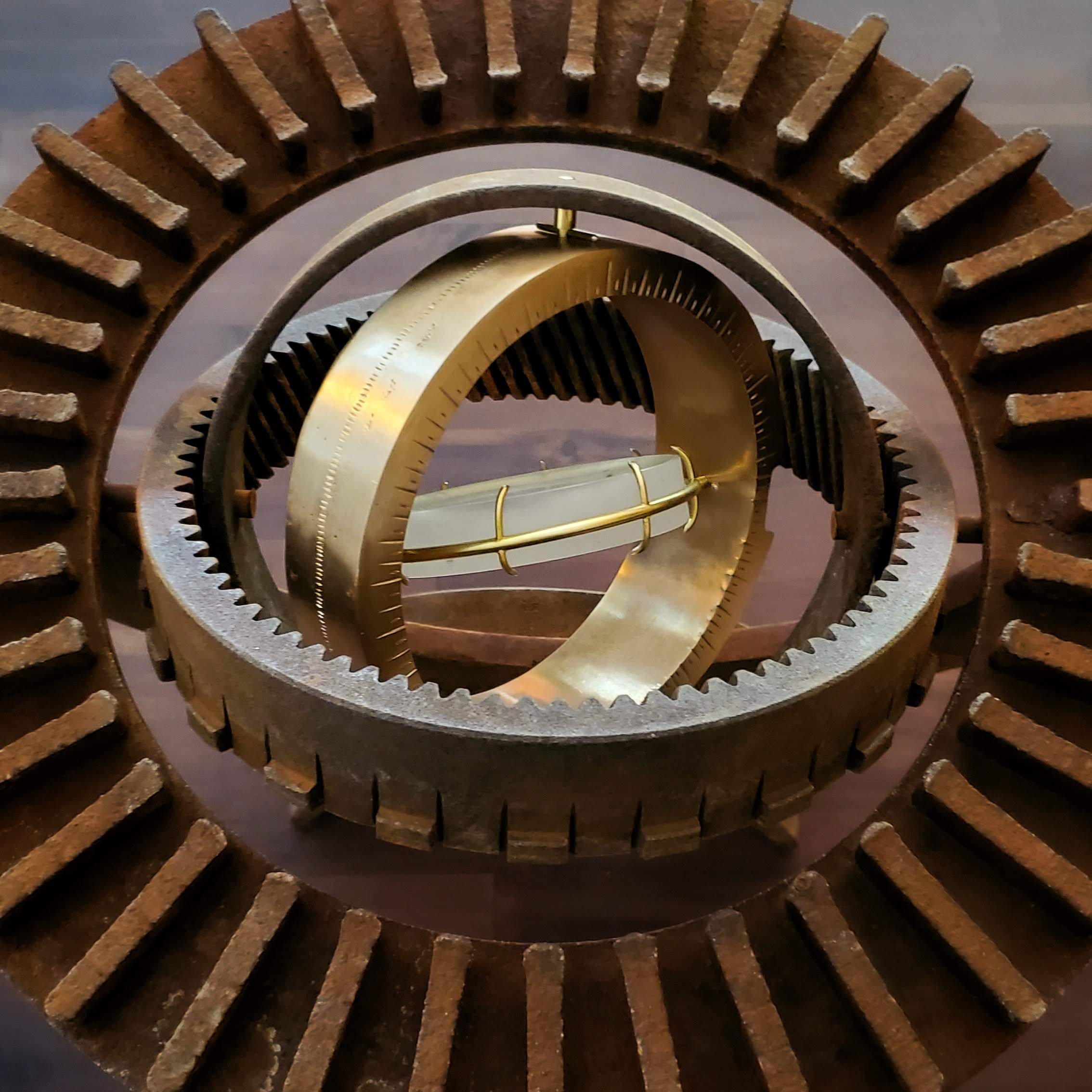 A view of the sculpture showing rusty rings, the bronze bezel, and the lens