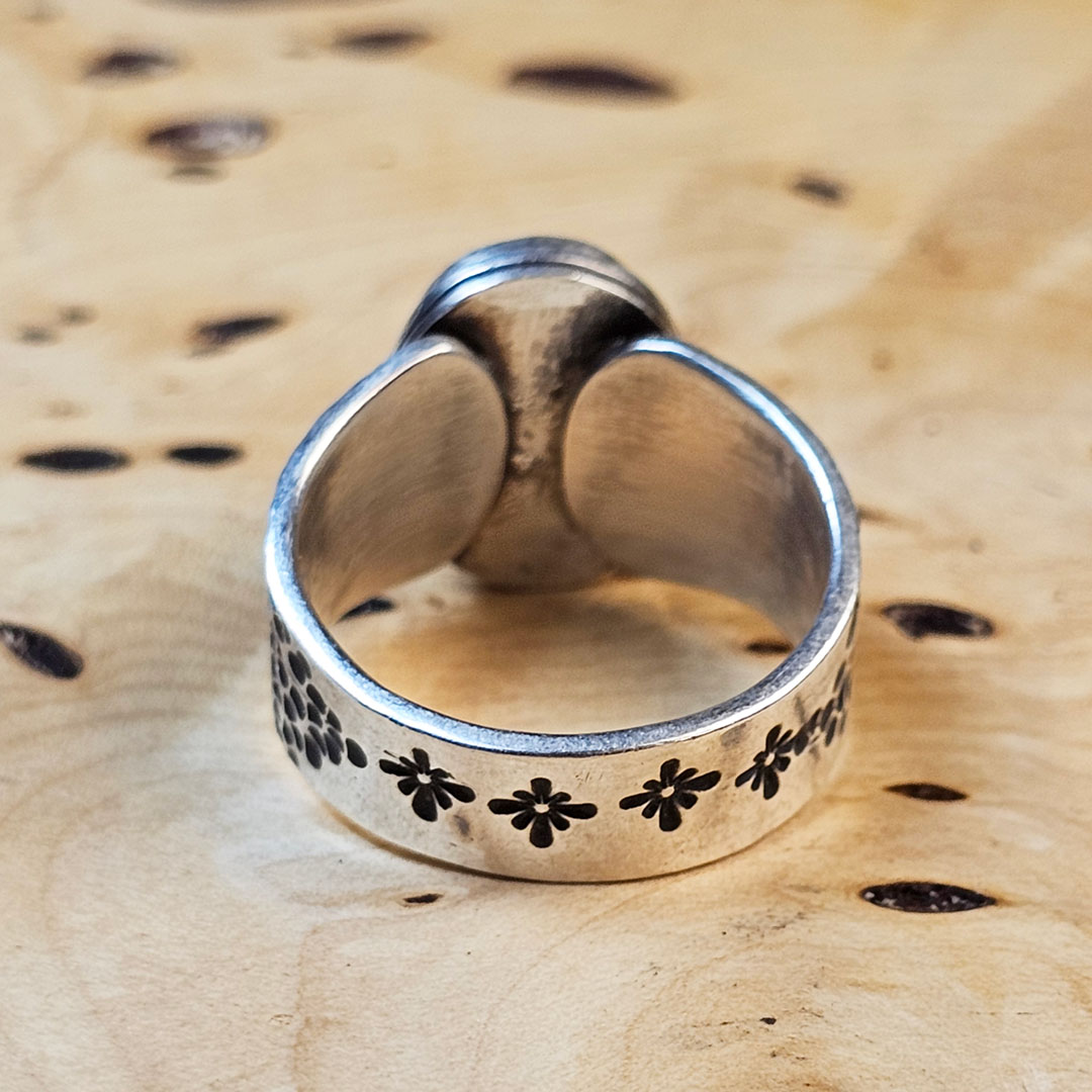 A stamped Hubei turquoise ring on a wood surface