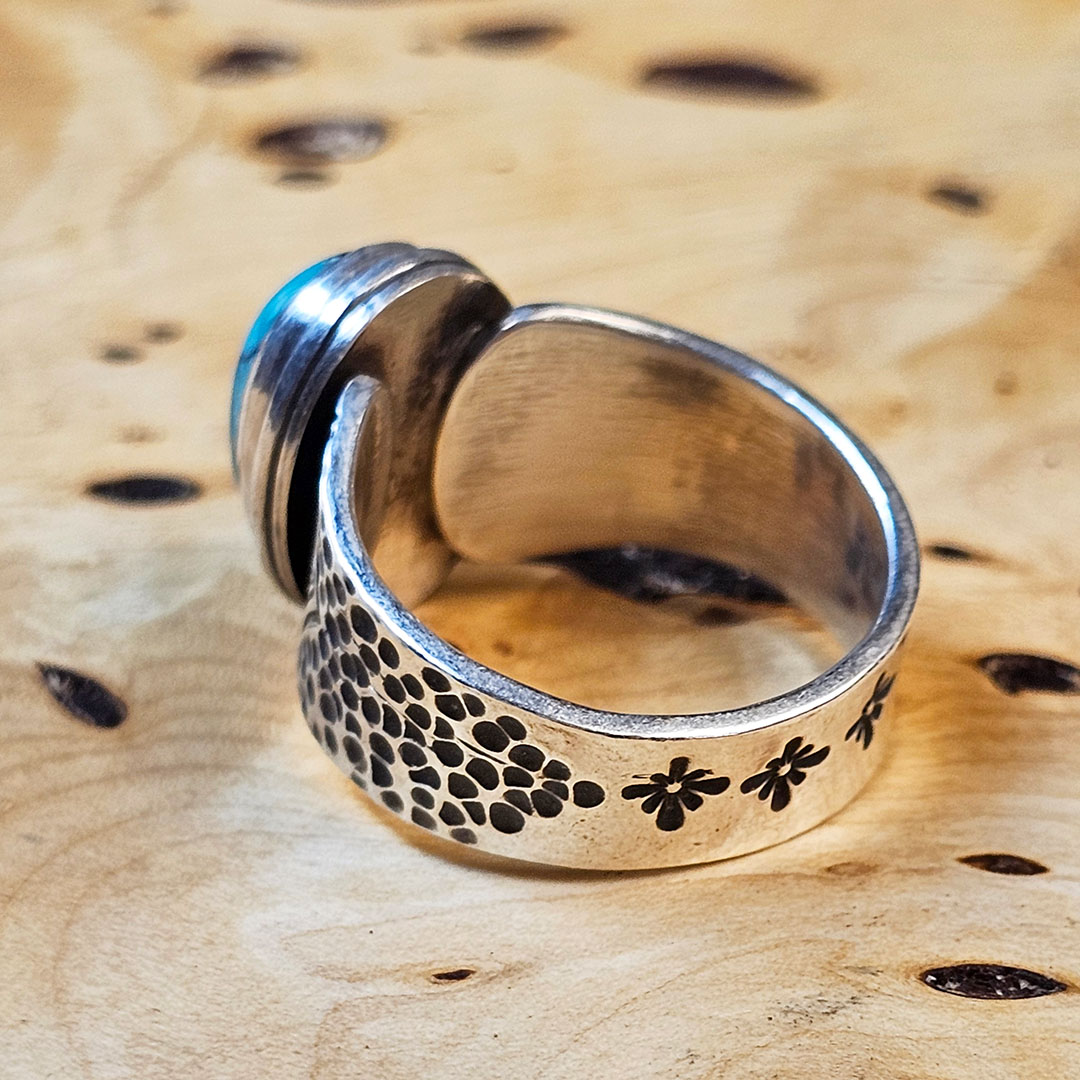 A stamped Hubei turquoise ring on a wood surface