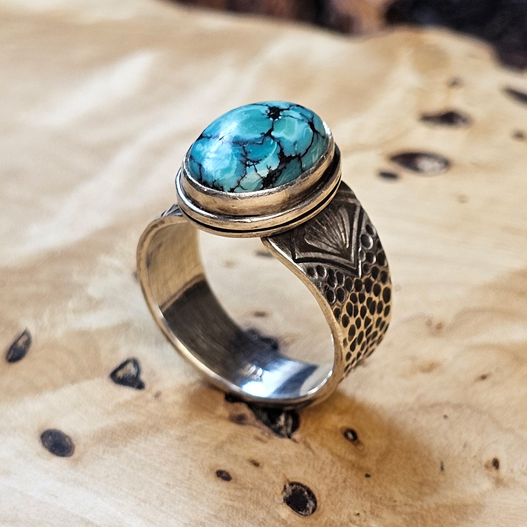 A stamped Hubei turquoise ring on a wood surface