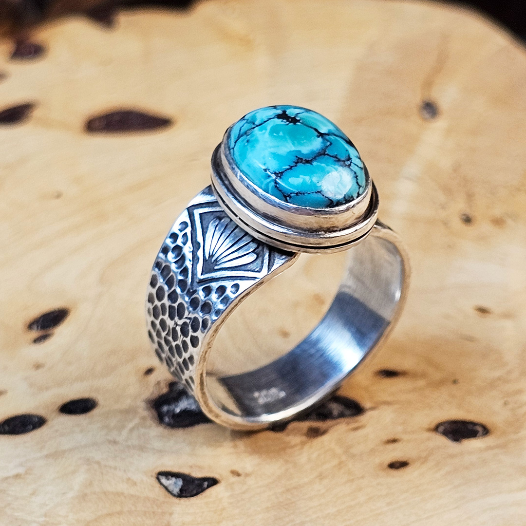 A stamped Hubei turquoise ring on a wood surface