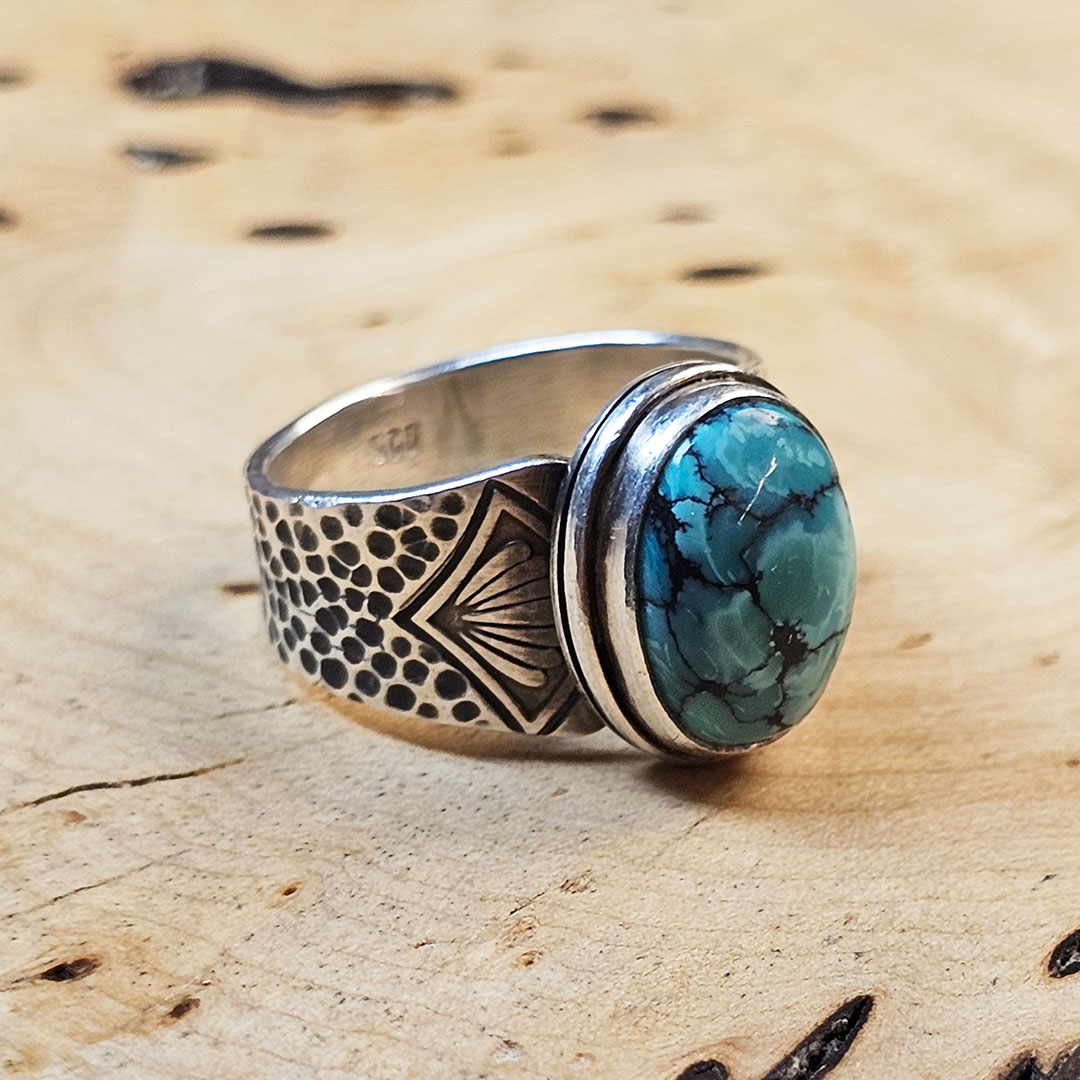 A stamped Hubei turquoise ring on a wood surface