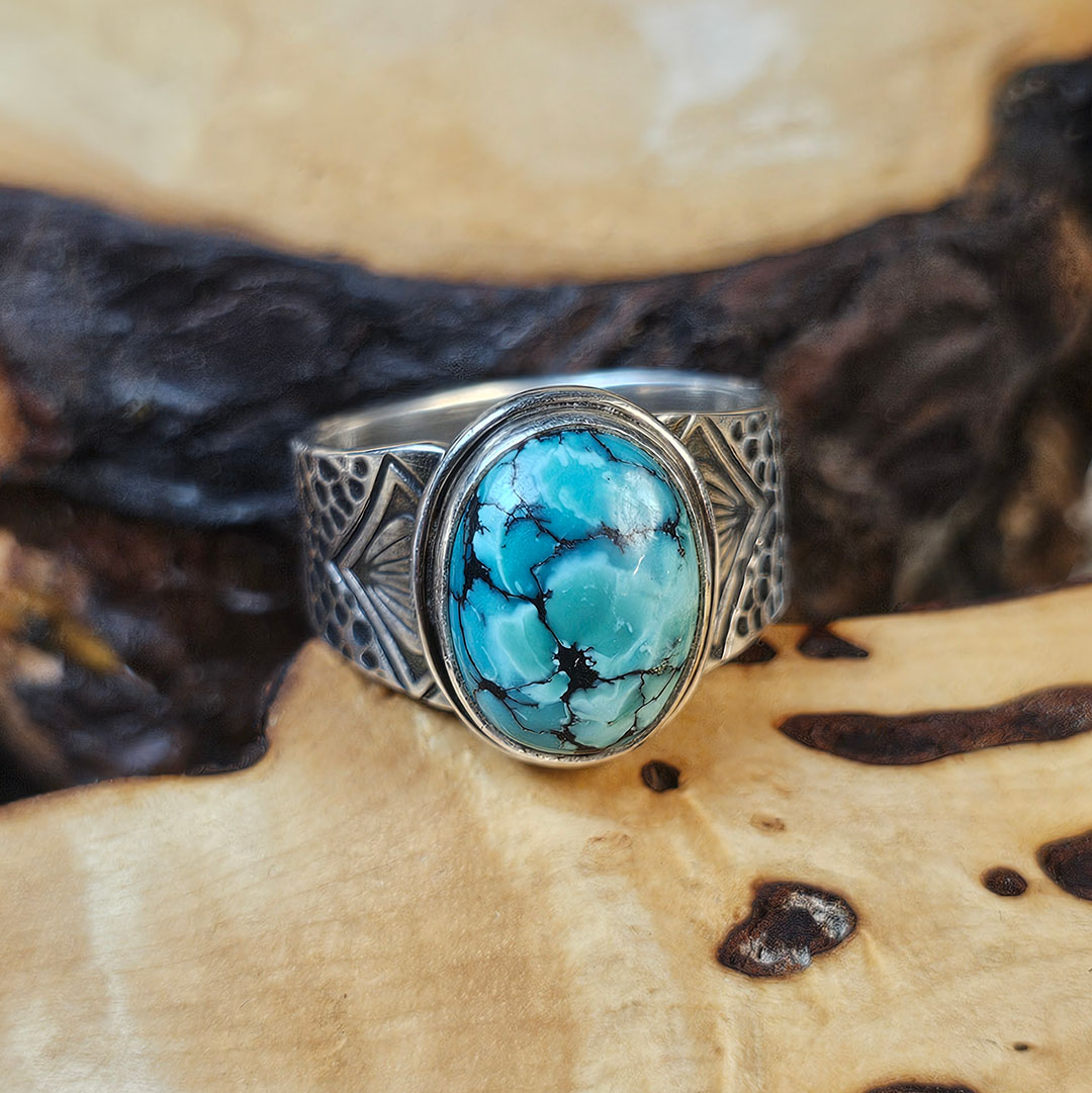 A stamped Hubei turquoise ring on a wood surface