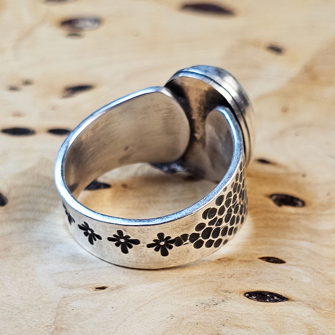 A stamped Hubei turquoise ring on a wood surface