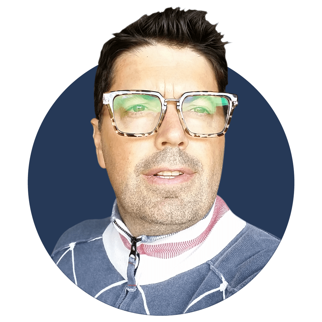 A business portrait of a man in horned-rimmed glasses.