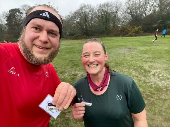 Selfie taken by Andrew of Andrew and Tamsyn. Andrew is wearing a new red parkrun 50 t-shirt and Tamsyn is wearing a green parkrun 250 t-shirt. They both look bedraggled but happy.