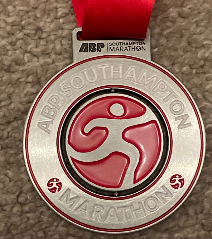 The 10k finish medal. It is red and silver with a spinning disc in the middle.