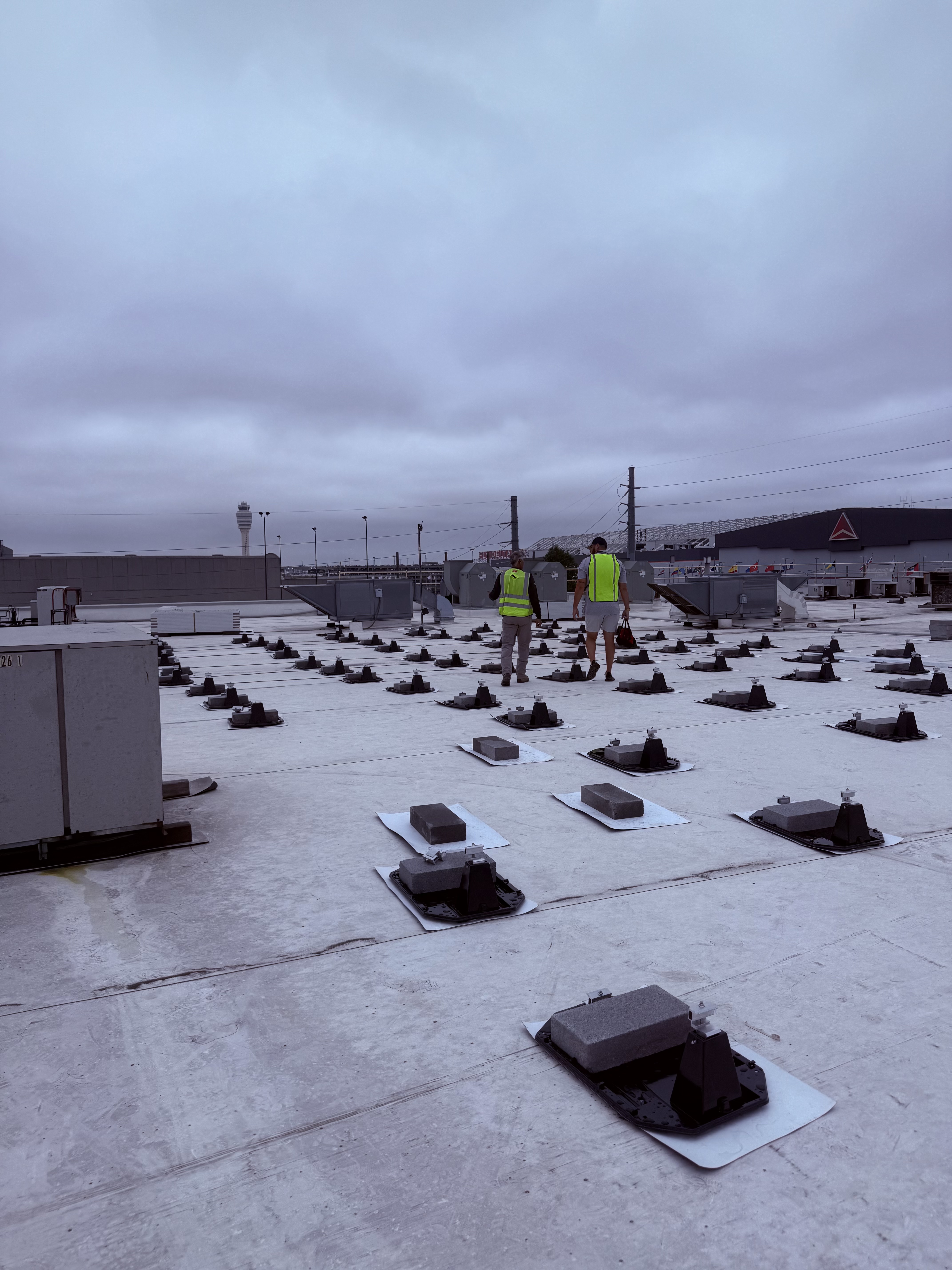 First Class Roofing crew installing solar panels on a flat roof