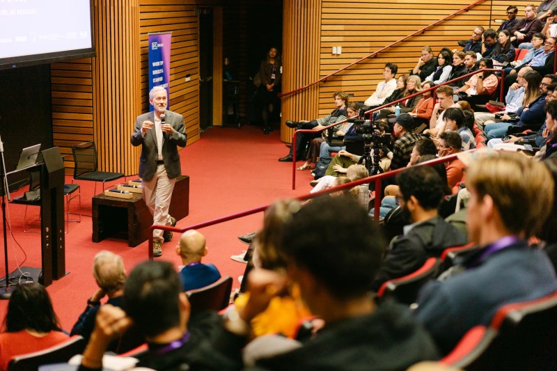 A speaker and the full auditorium at DECODE Conference.