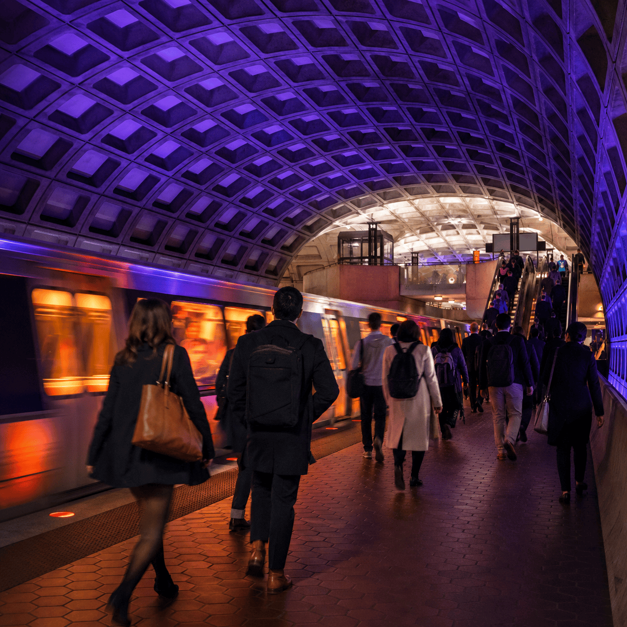 Commuters walking through a Washington, D.C. Metro station beneath its vaulted coffered ceiling