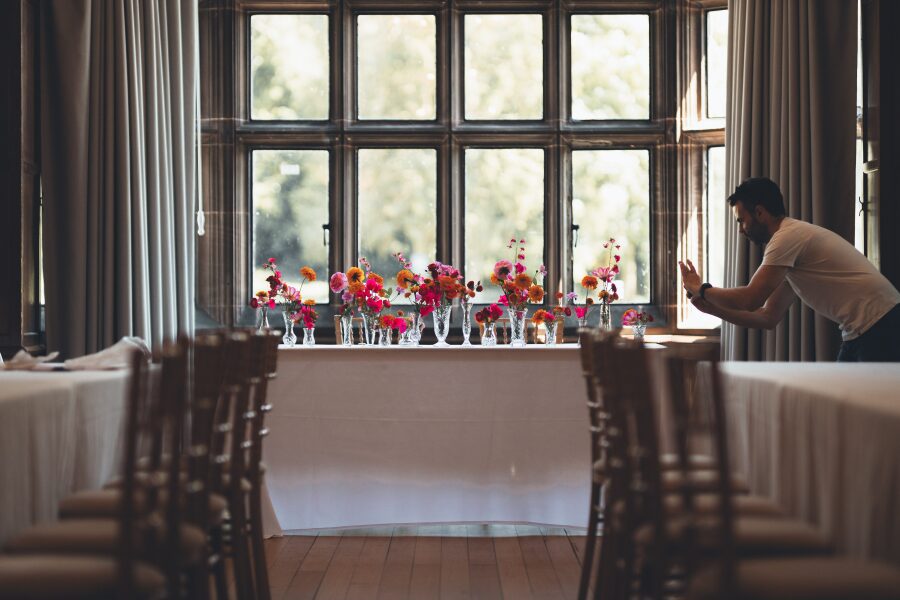 wedding breakfast room vibrant floral small centrepieces orange pink colour scheme