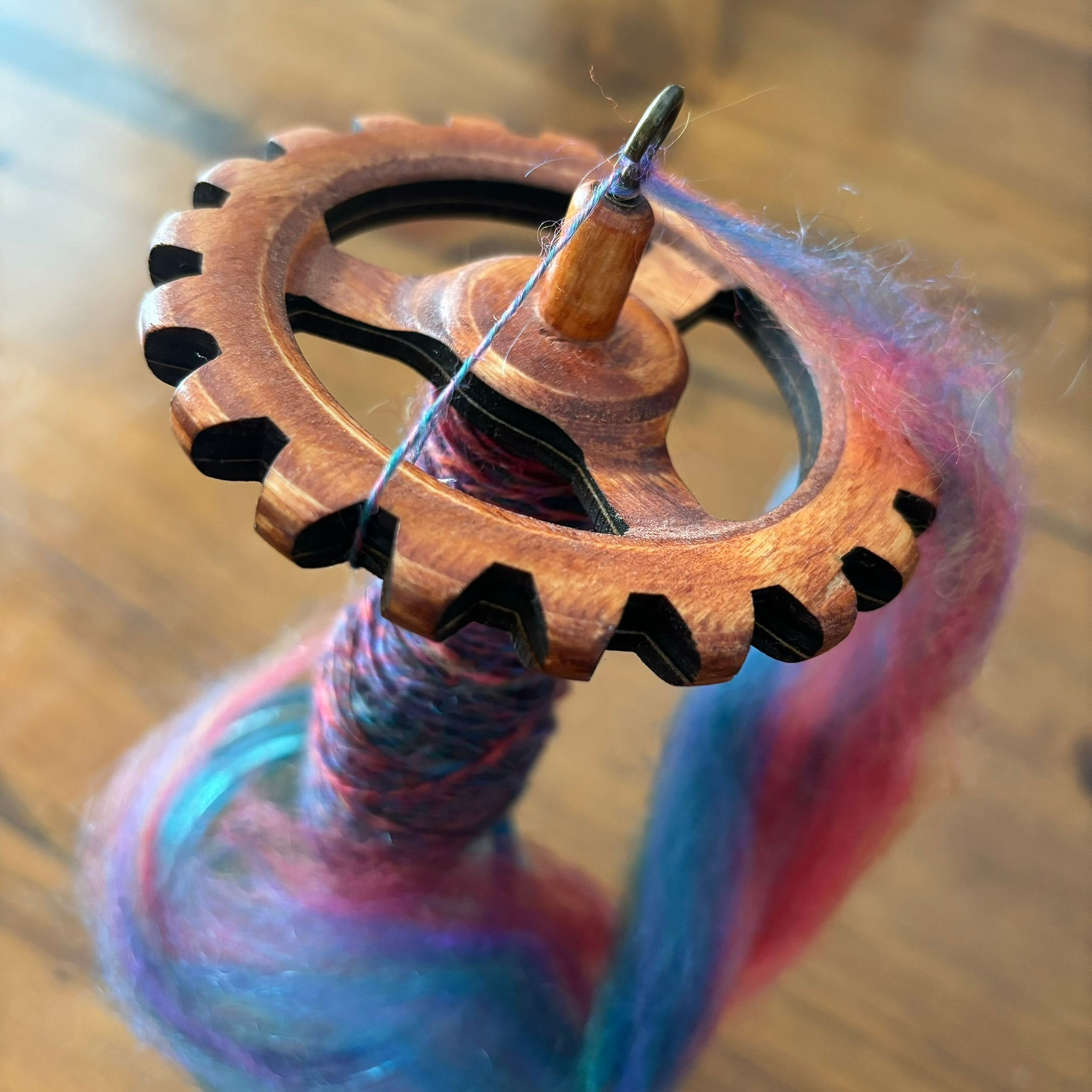 Drop spindle in blue mason jar on wood floor.